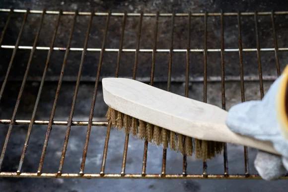 Reinigung eines Grillrosts mit einer Bürste